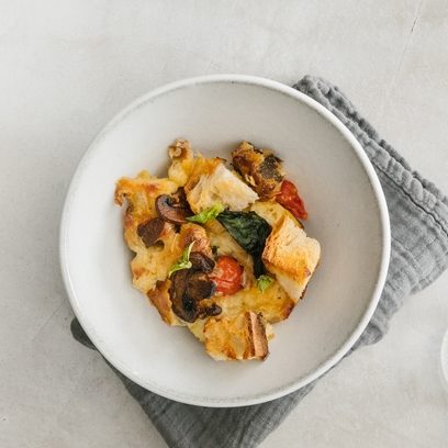 caramelized mushroom and roasted cherry tomato strata in a bowl