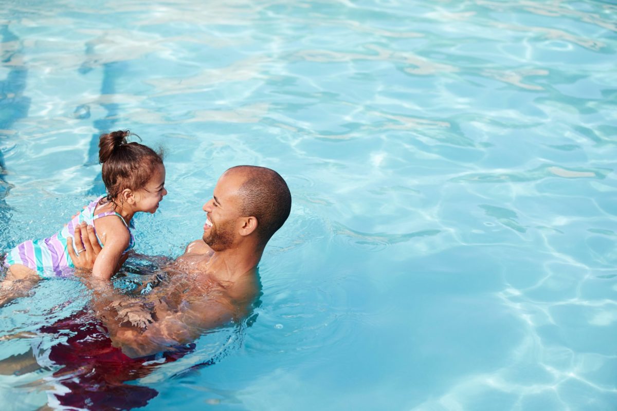 Un père et sa fille dans une piscine au sel